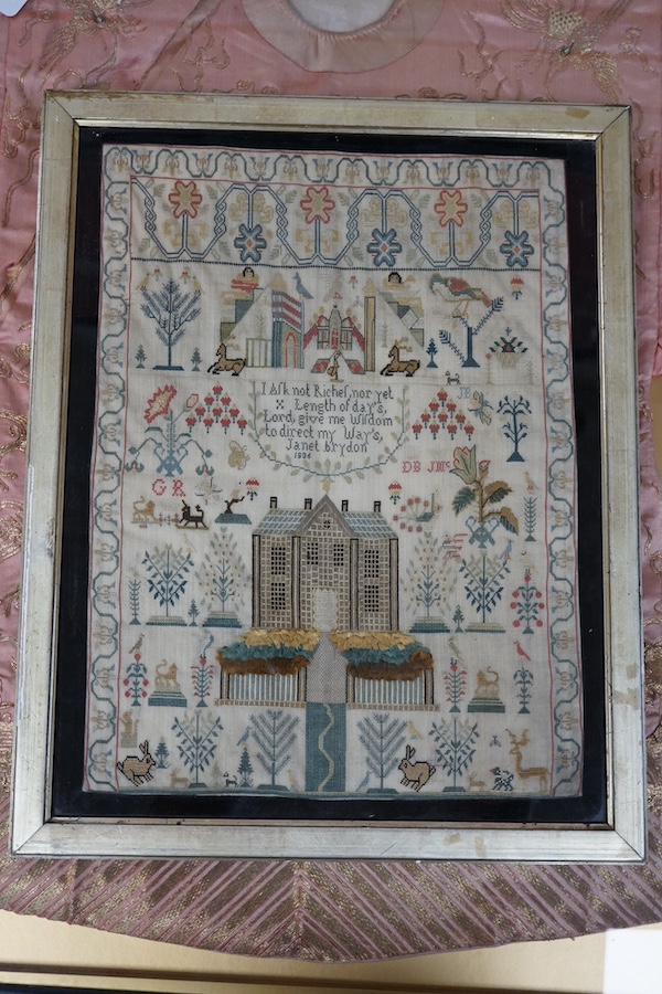 A George lll needlework sampler dated 1806, by Janet Brydon. Worked on fine linen, the sampler embroidered with ornate motifs of angels, birds, deer, lions and a castle around a short embroidered script; I ask not riches